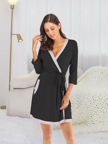 Elegant tie waist robe with pockets in black, featuring a surplice neck design, perfect for lounging.