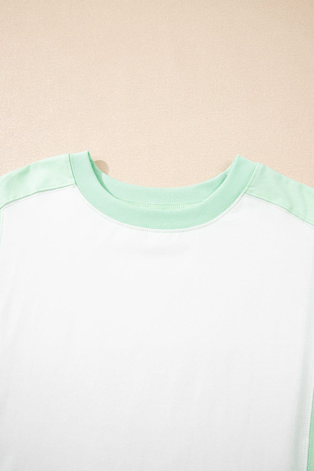 Light green color block crew neck t-shirt with exposed seam detail.