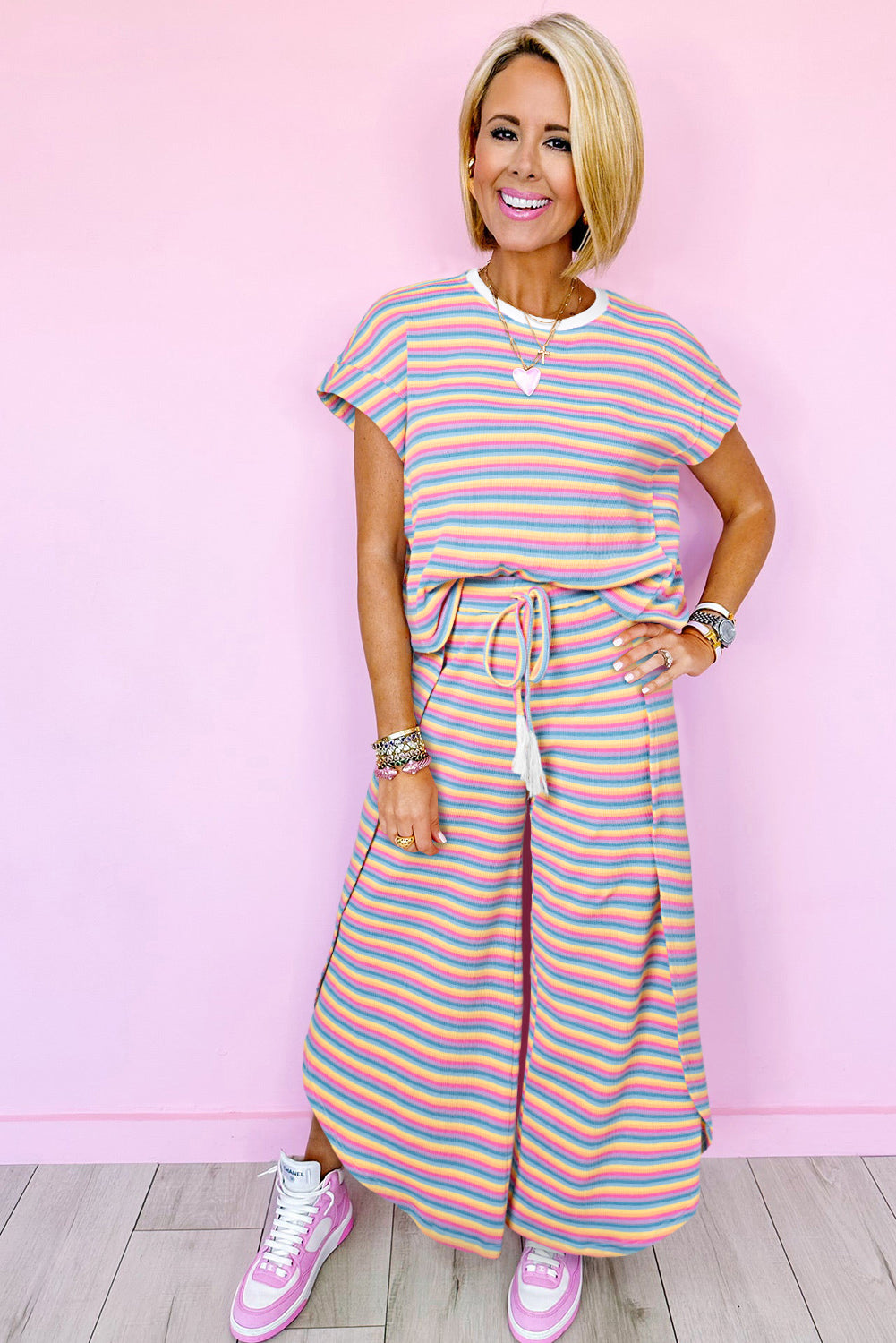 Chic pink striped rainbow tee and tasseled wide leg pants ensemble