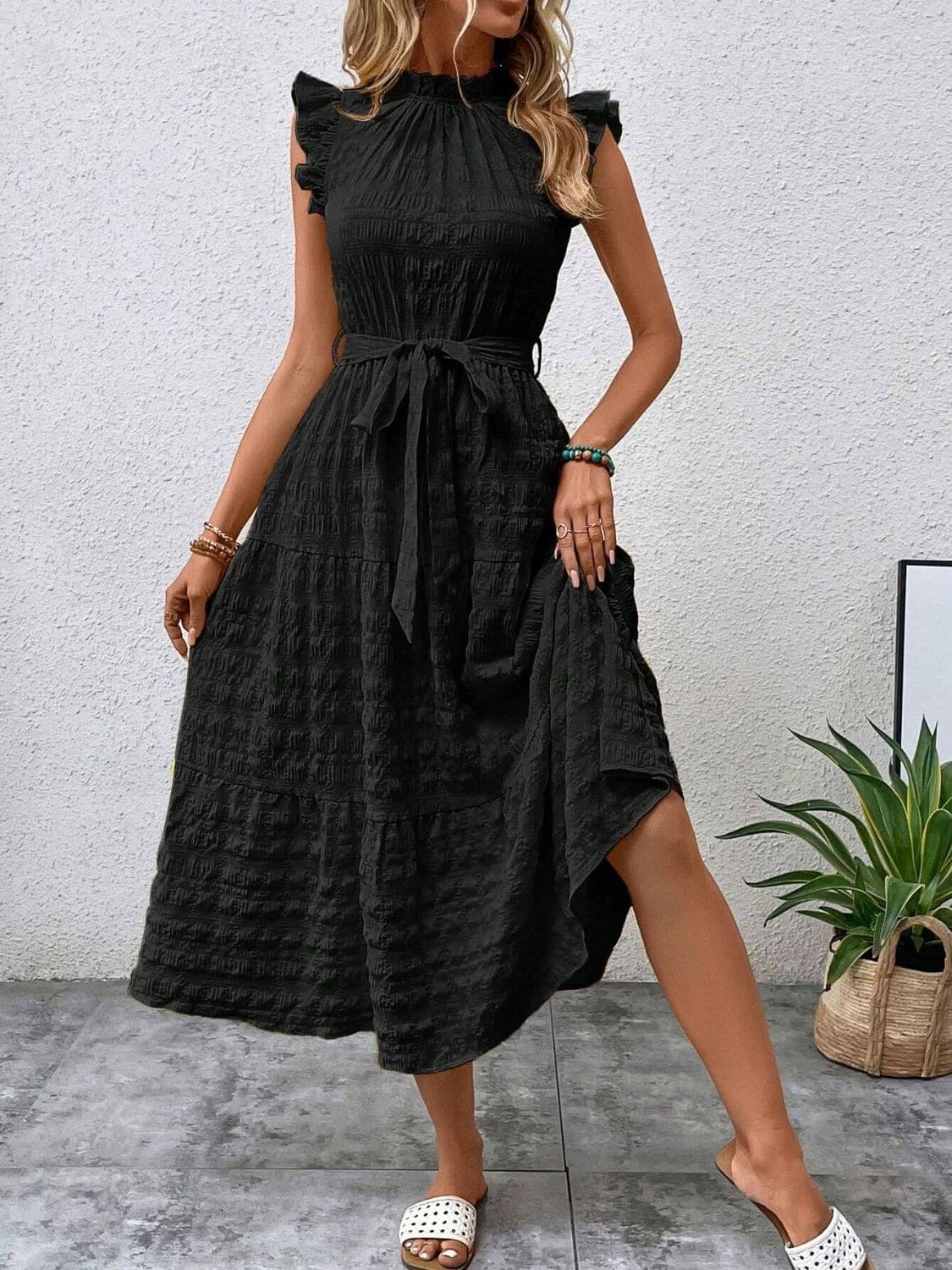 Ruffled cap sleeve midi dress with tie waist and opaque black fabric.