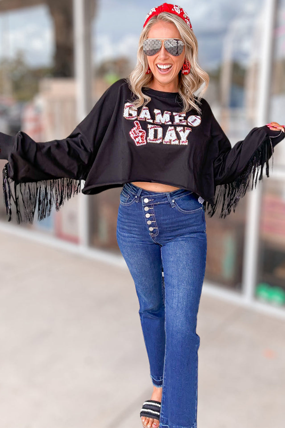 Sparkle on game day with a black cropped rugby sweatshirt featuring tassels and sequins