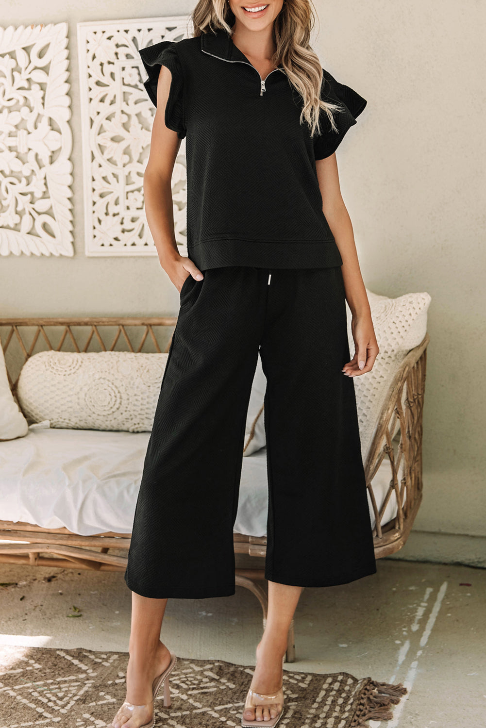 Chic black flutter sleeve top and wide-leg pants ensemble