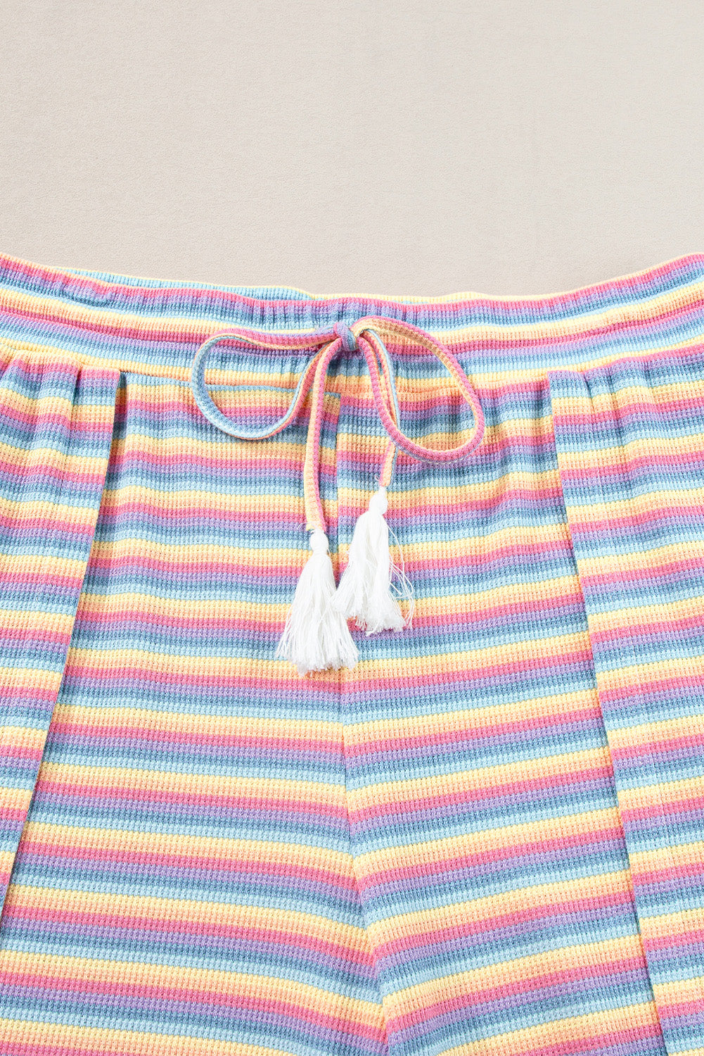 Chic pink striped rainbow tee and tasseled wide leg pants ensemble