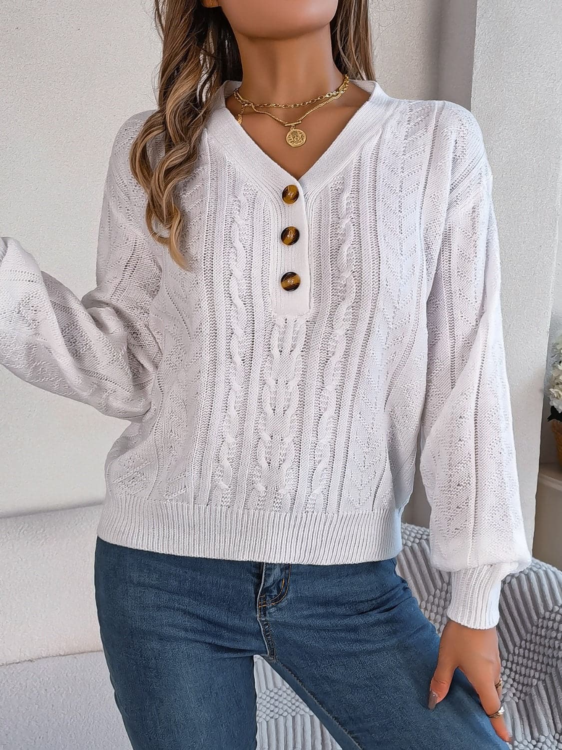 Chic cable-knit v-neck sweater with buttoned details