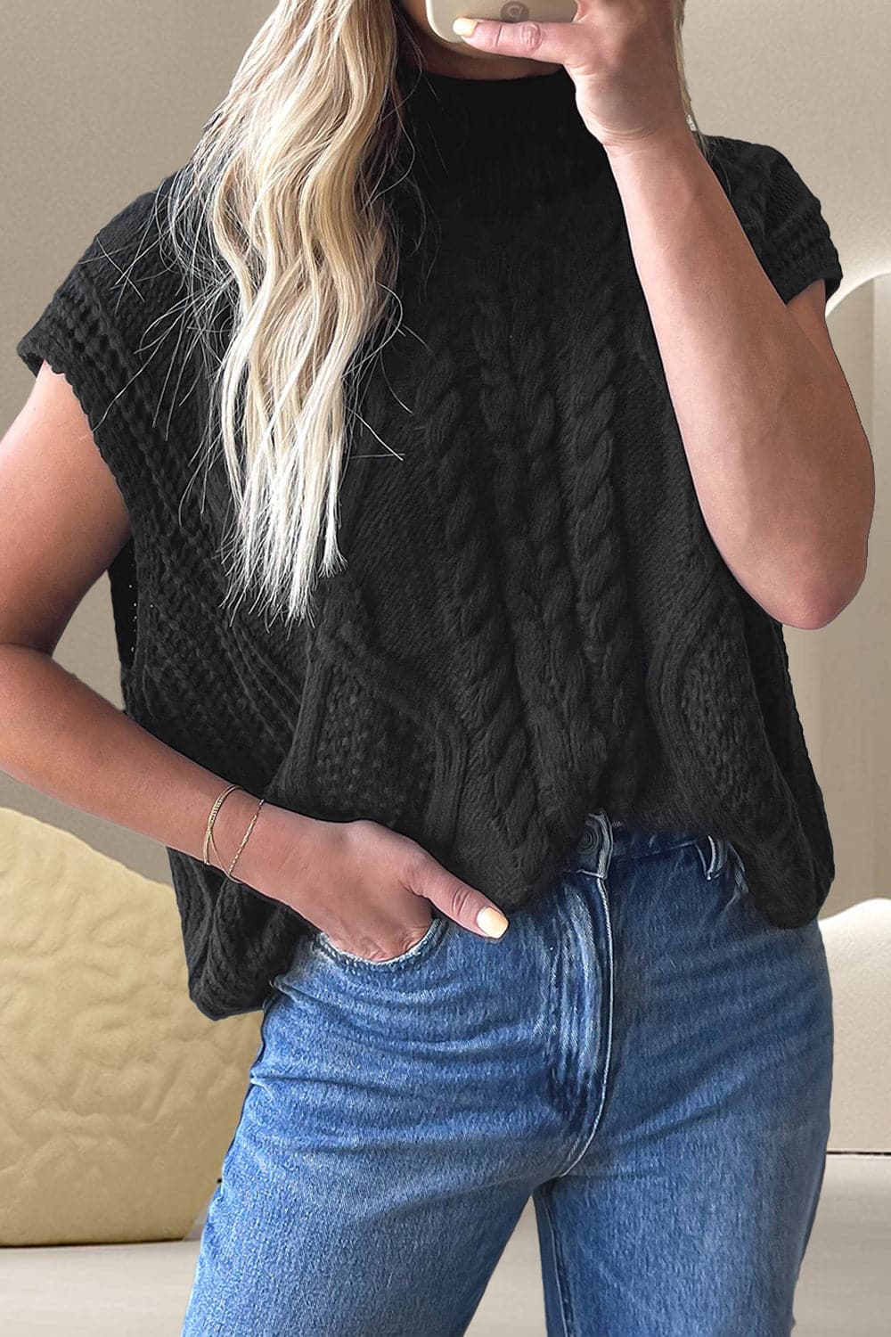 Cozy cable-knit mock neck sweater featuring a stretchy material blend of 60% cotton and 40% acrylic, shown in black, paired with jeans.