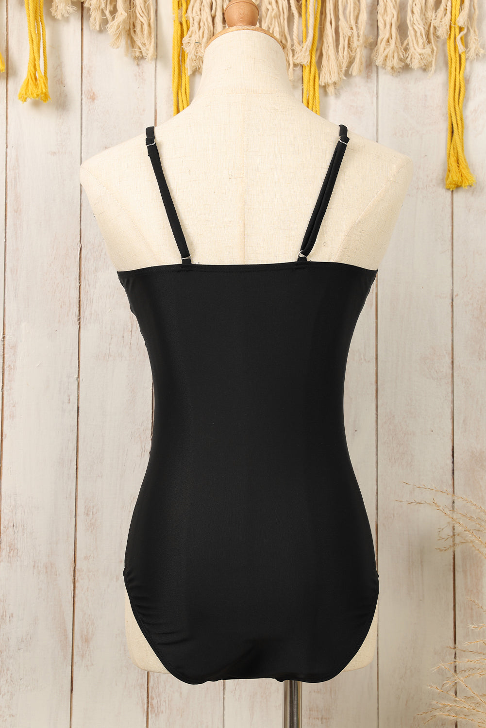 Chic black one-piece swimsuit with metal V detail and adjustable straps