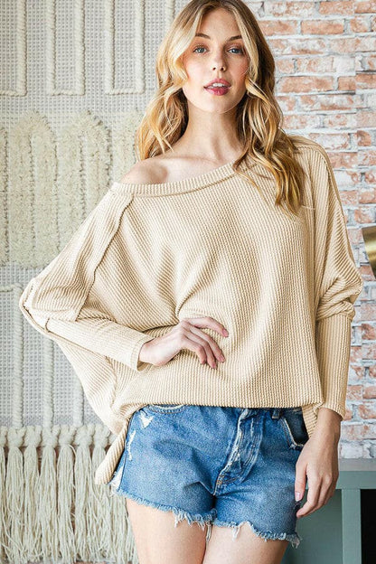 Exposed seam lantern sleeve top with unique design, ideal for versatile styling.