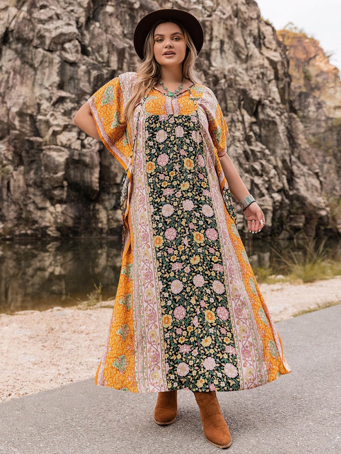 Plus size elegant maxi dress with tie neck detail and floral pattern.