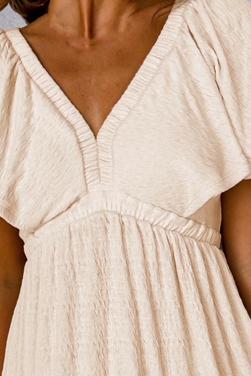 Tied V-Neck Short Sleeve Mini DressTied V-Neck Short Sleeve Mini Dress
 Indulge in Effortless Elegance with Our Tied V-Neck Short Sleeve Mini Dress. Elevate your style effortlessly with this versatileLove Salve -Neck Short Sleeve Mini Dressswimwear