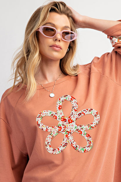 Floral graphic wide-sleeve top with exposed seam detail in grapefruit orange