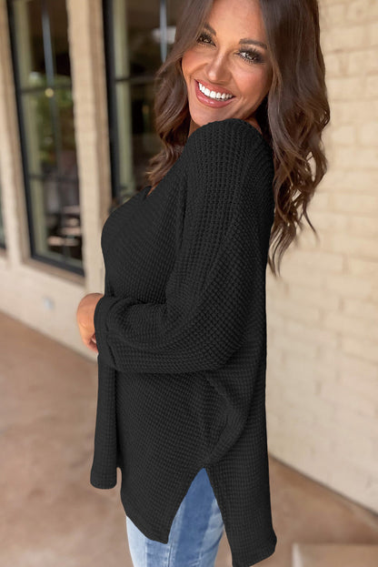 Chic black waffle knit V-neck top with side slits and loose fit