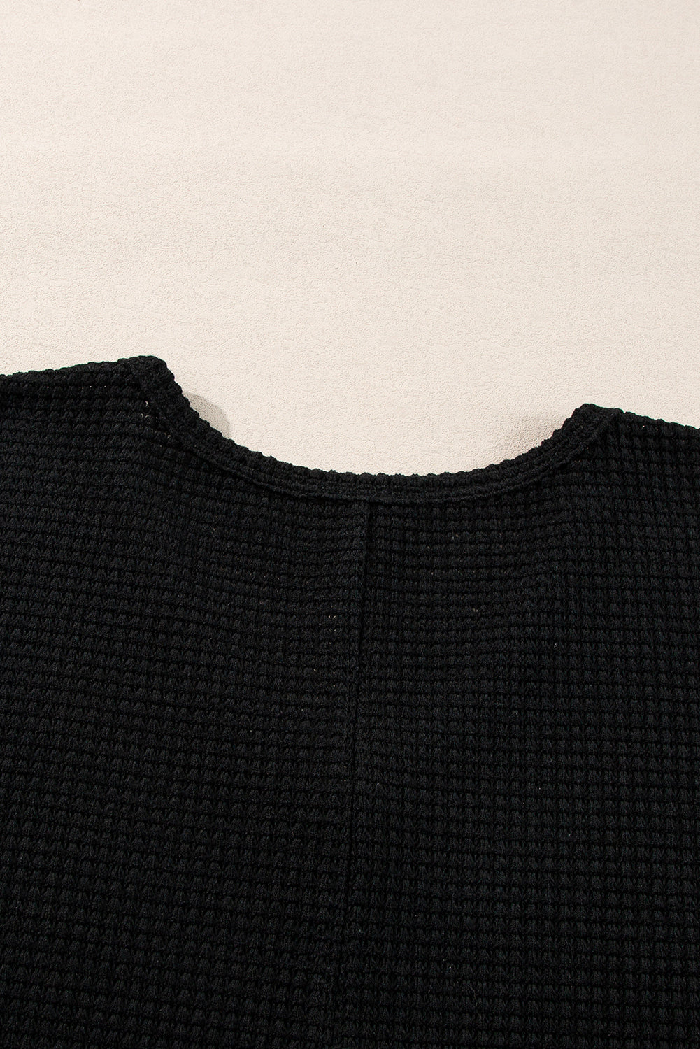 Chic black waffle knit V-neck top with side slits and loose fit