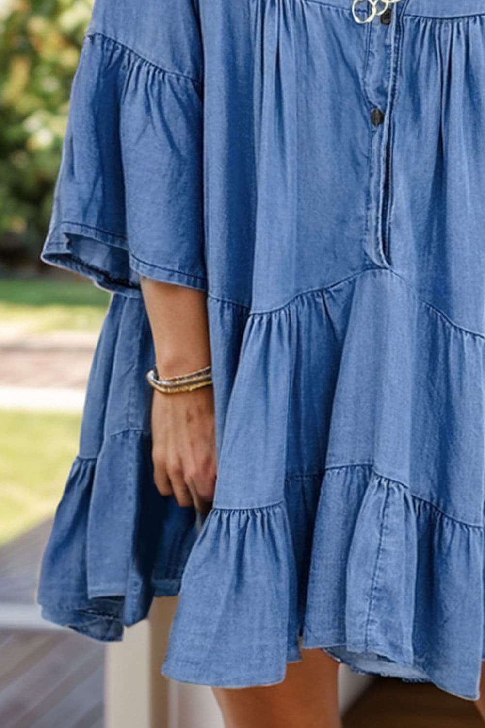 Trendy denim dress with ruffled sleeves and notched flare detail.