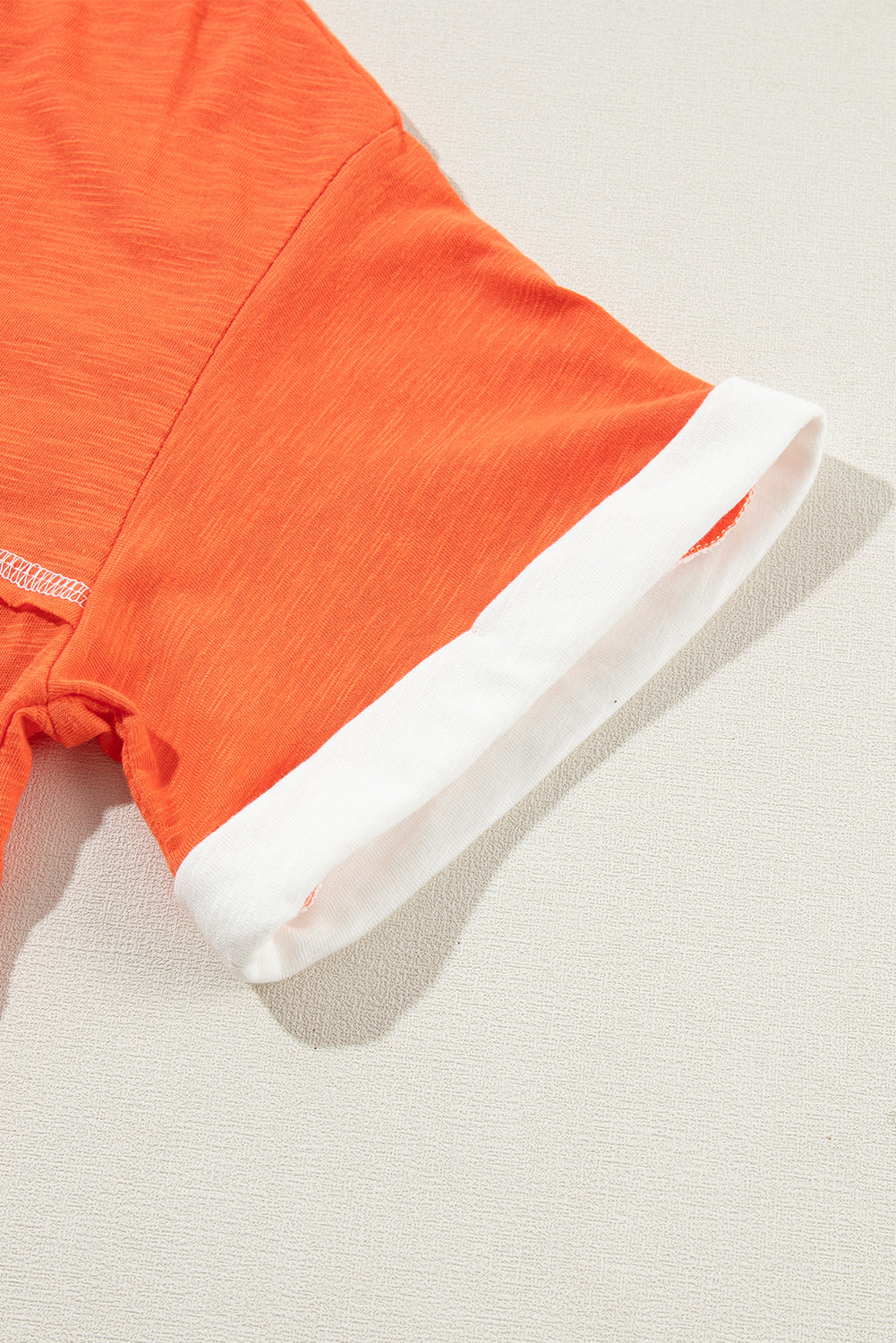 Grapefruit orange exposed seam V-neck tee with contrast trim