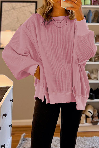 Pink waffle knit bishop sleeve split oversized sweatshirt, relaxed fit, trendy design.