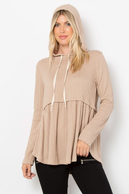 Beige stage peplum cable knit hoodie with drawstring and long sleeves.