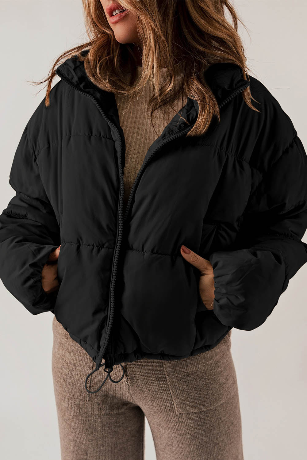 Sleek black puffer coat with zip closure and drawstring hem