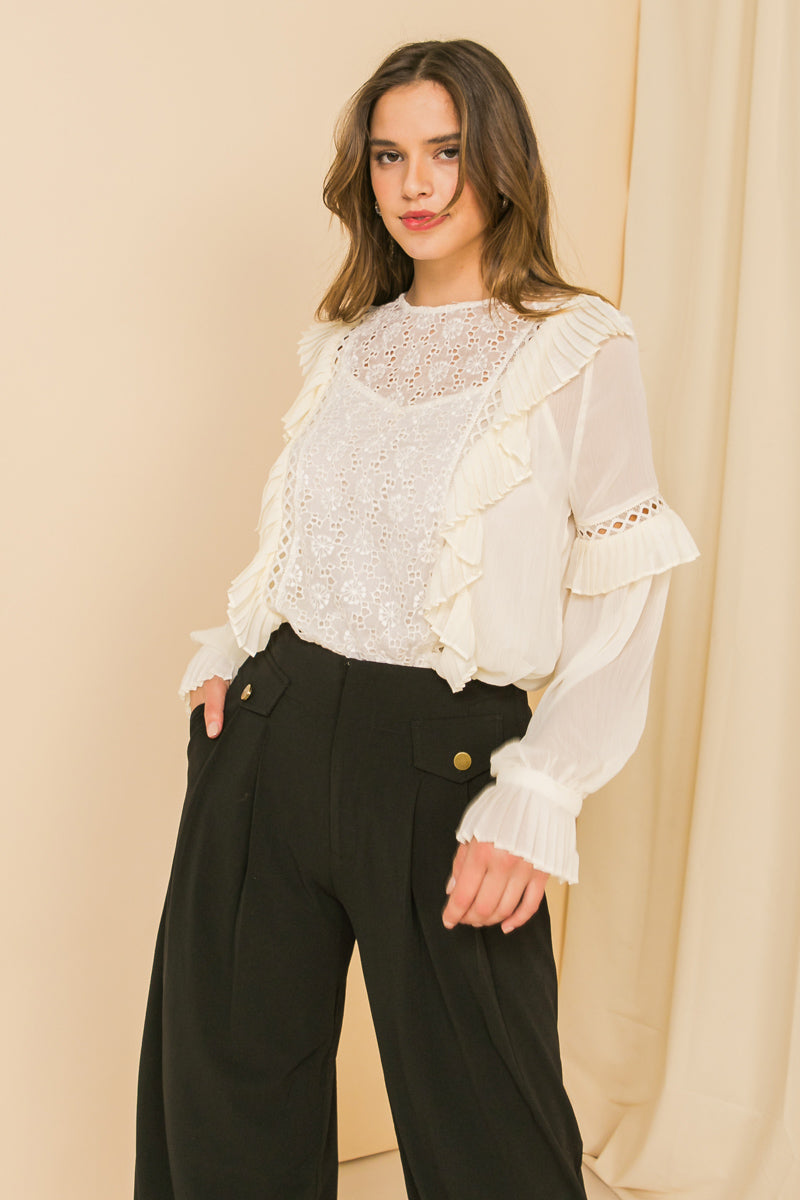 Woman wearing HIGH EXPECTATIONS KNIT EYELET TOP with keyhole back, pleated sleeves, and lace insets.