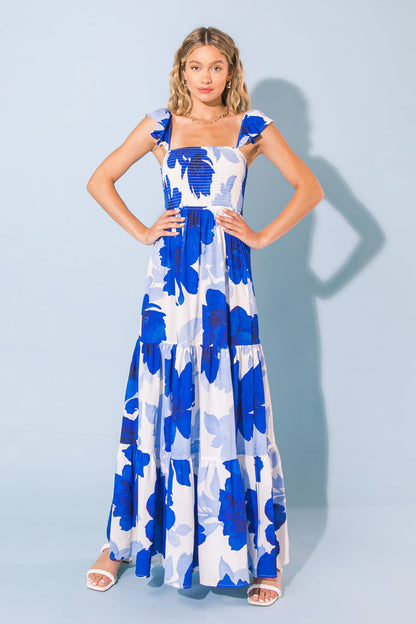 Blue floral print moving maxi dress with adjustable ruffled straps and square neckline.