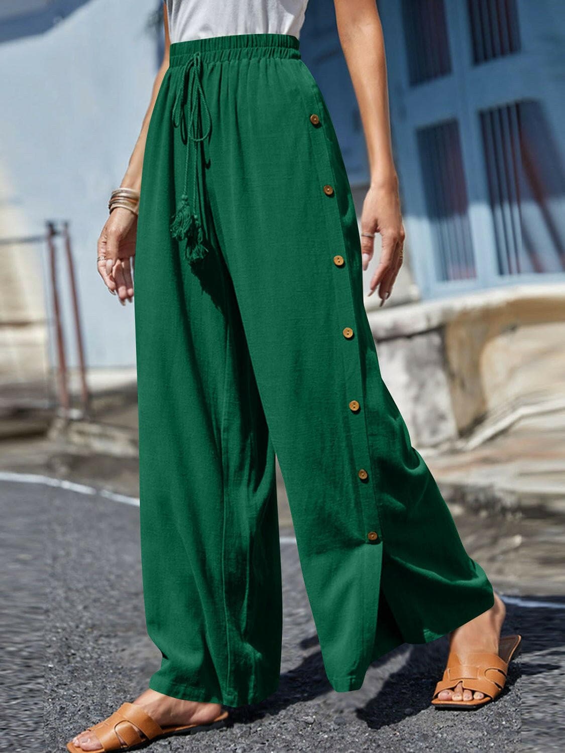 Chic tassel accent wide leg trousers in green with decorative buttons and waist tie.