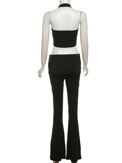 Chic halter neck crop top paired with flared pants set in solid black, leisure style.