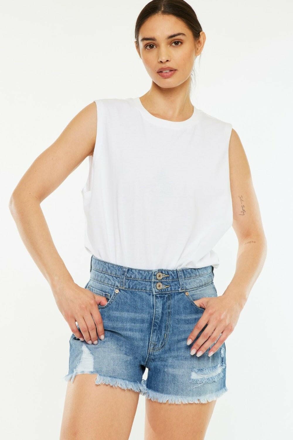 Kancan high waist raw edge denim shorts on model in white top, showcasing chic summer style.