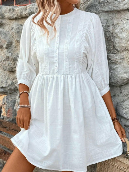 Elegant white lace button-up dress with three-quarter sleeves.