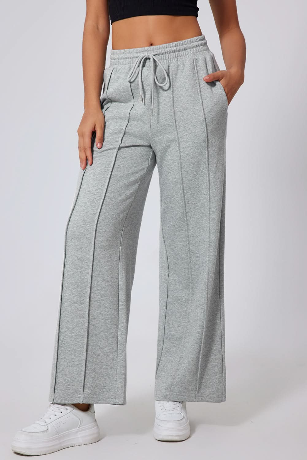 Gray wide leg sweatpants with seamed detailing and drawstring high waist.