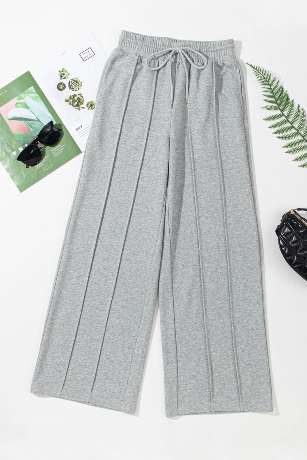 Chic gray wide leg sweatpants with seamed detailing and adjustable drawstring.