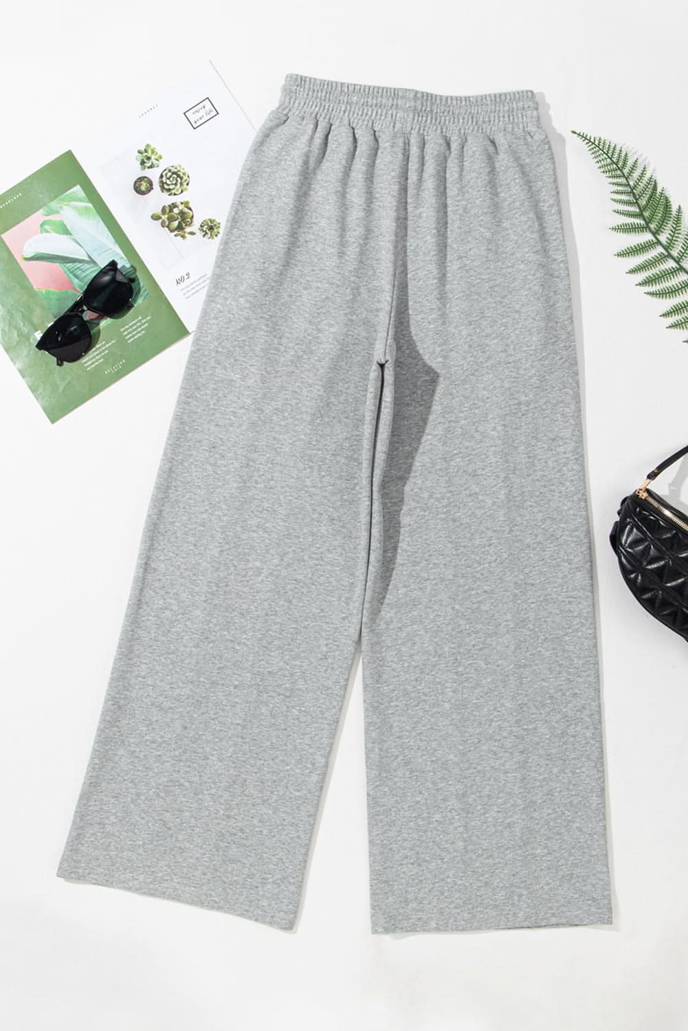 Chic gray wide leg sweatpants with adjustable drawstring high waist and seamed detailing.