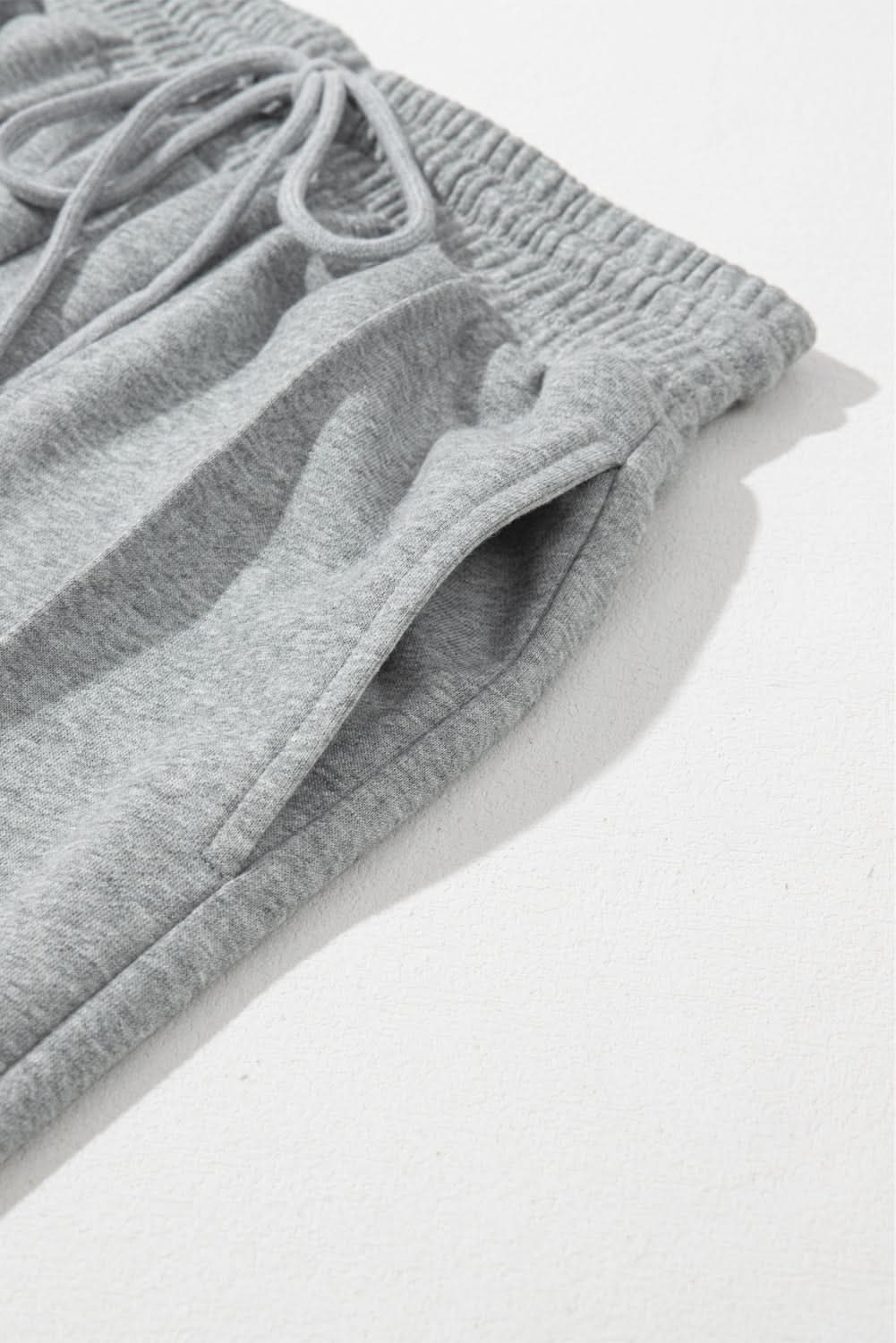 Gray wide leg sweatpants with drawstring and seam detailing.