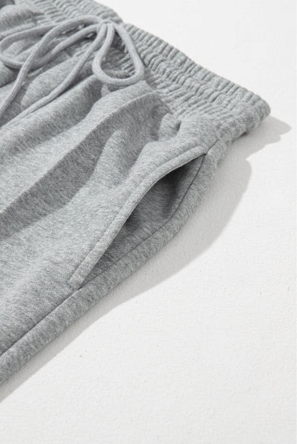 Gray wide leg sweatpants with drawstring and seam detailing.