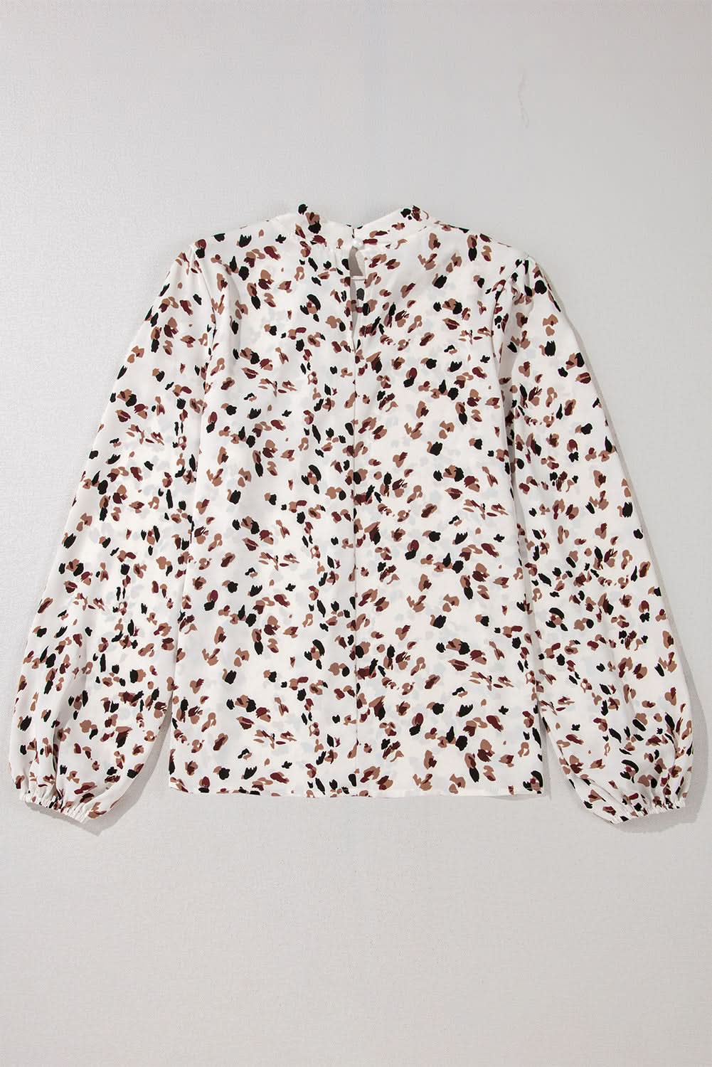 White leopard print lantern sleeve mock neck pleated blouse.