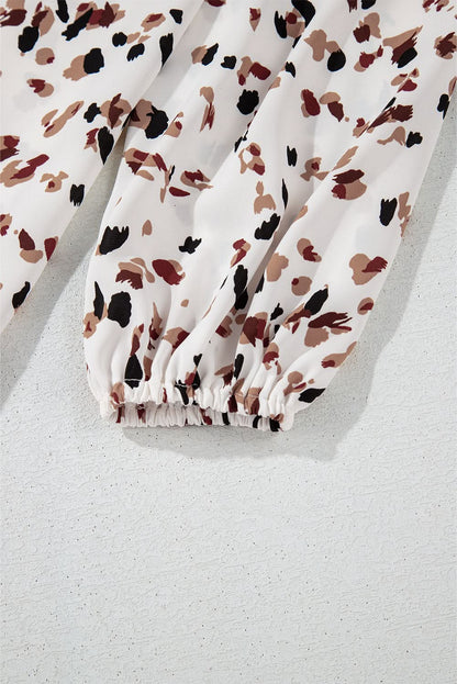 White leopard print lantern sleeve mock neck pleated blouse fabric detail.