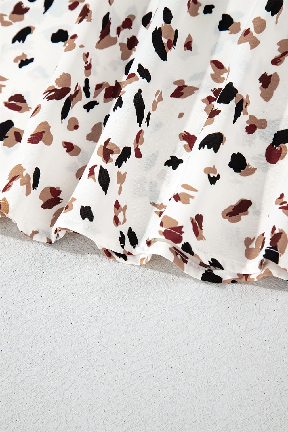 White leopard print lantern sleeve blouse fabric detail.