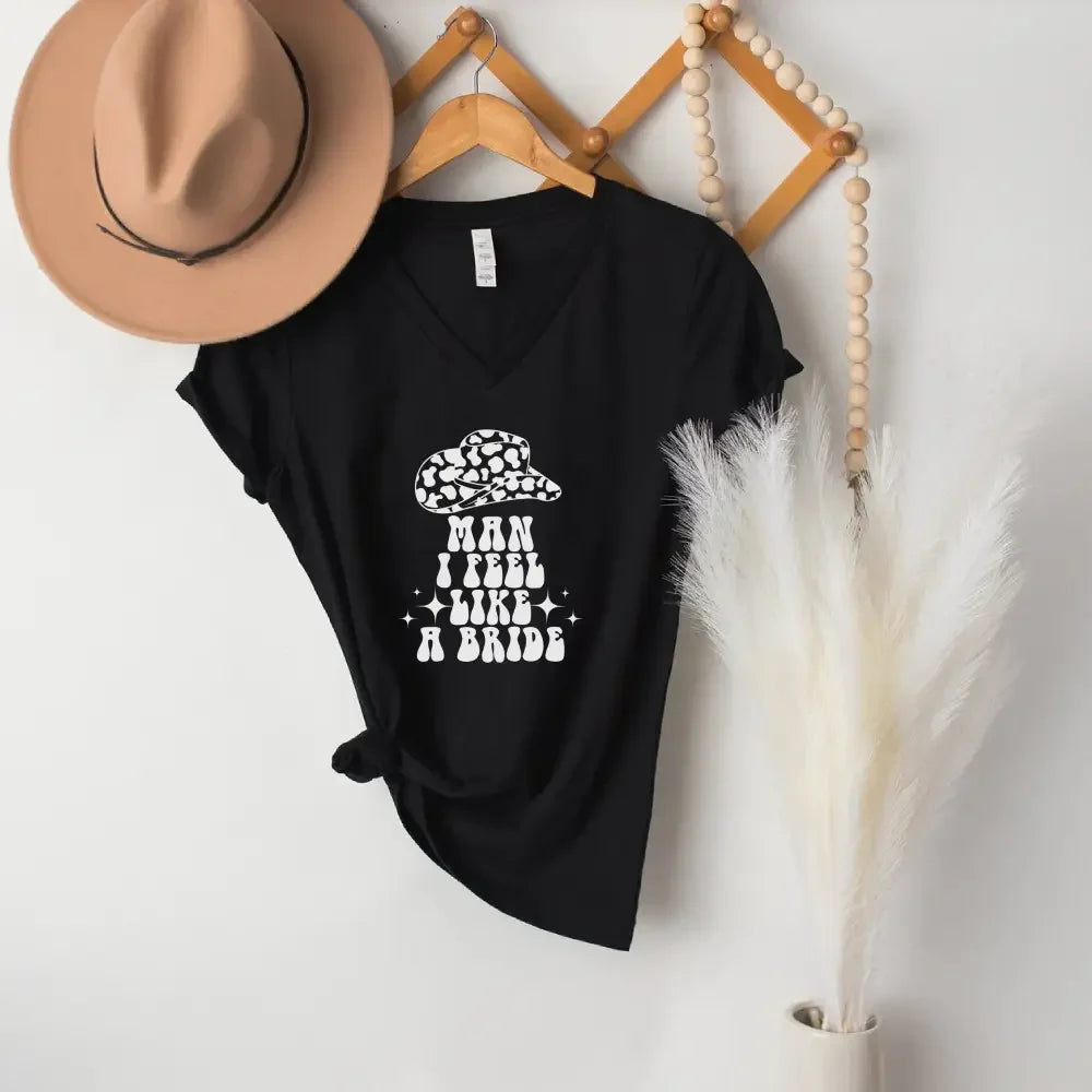 A flat lay of the Adorb.co 'Man I Feel Like a Bride' matching t-shirts for a bachelorette party, neatly folded.