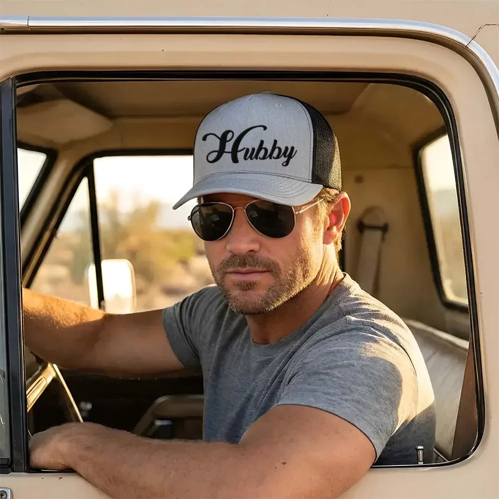 Adorb.co Embroidered Hubby Trucker Hat in black with white script embroidery. Classic mesh cap for a husband or groom gift.