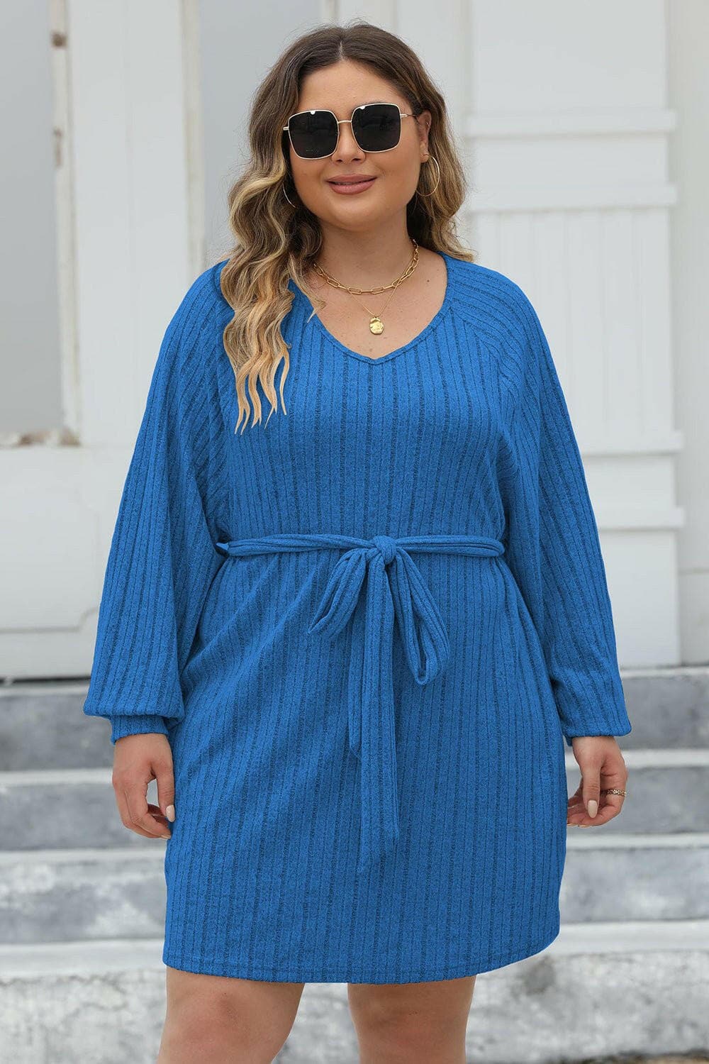 Plus size blue ribbed sweater dress with tie front and long sleeves.