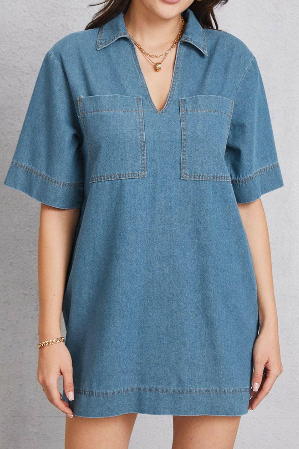 Denim collared mini dress with pockets and short sleeves.