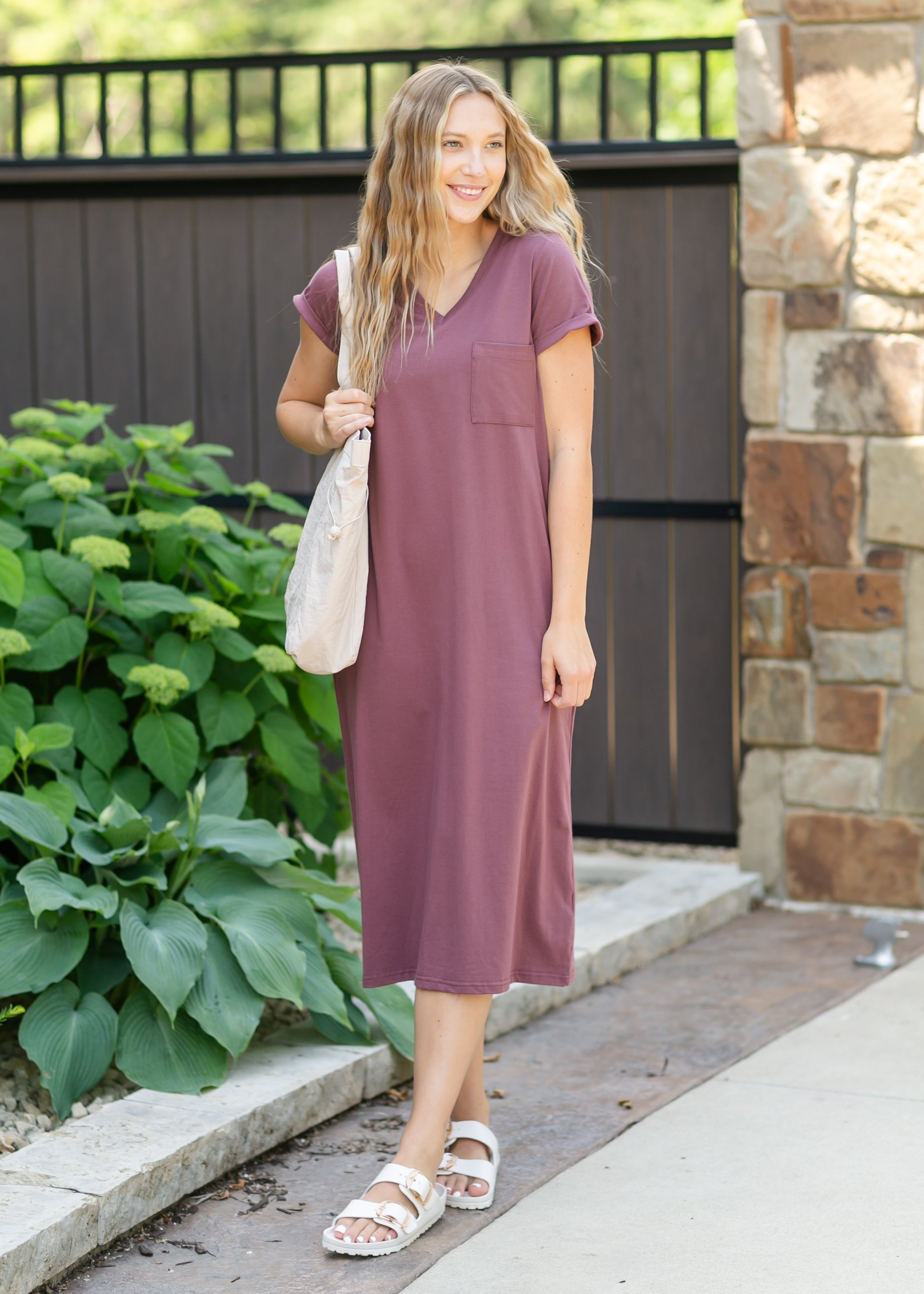 Side profile of the Inherit Co. Finley V-neck T-shirt Dress, showcasing its relaxed fit and comfortable knee-length design.