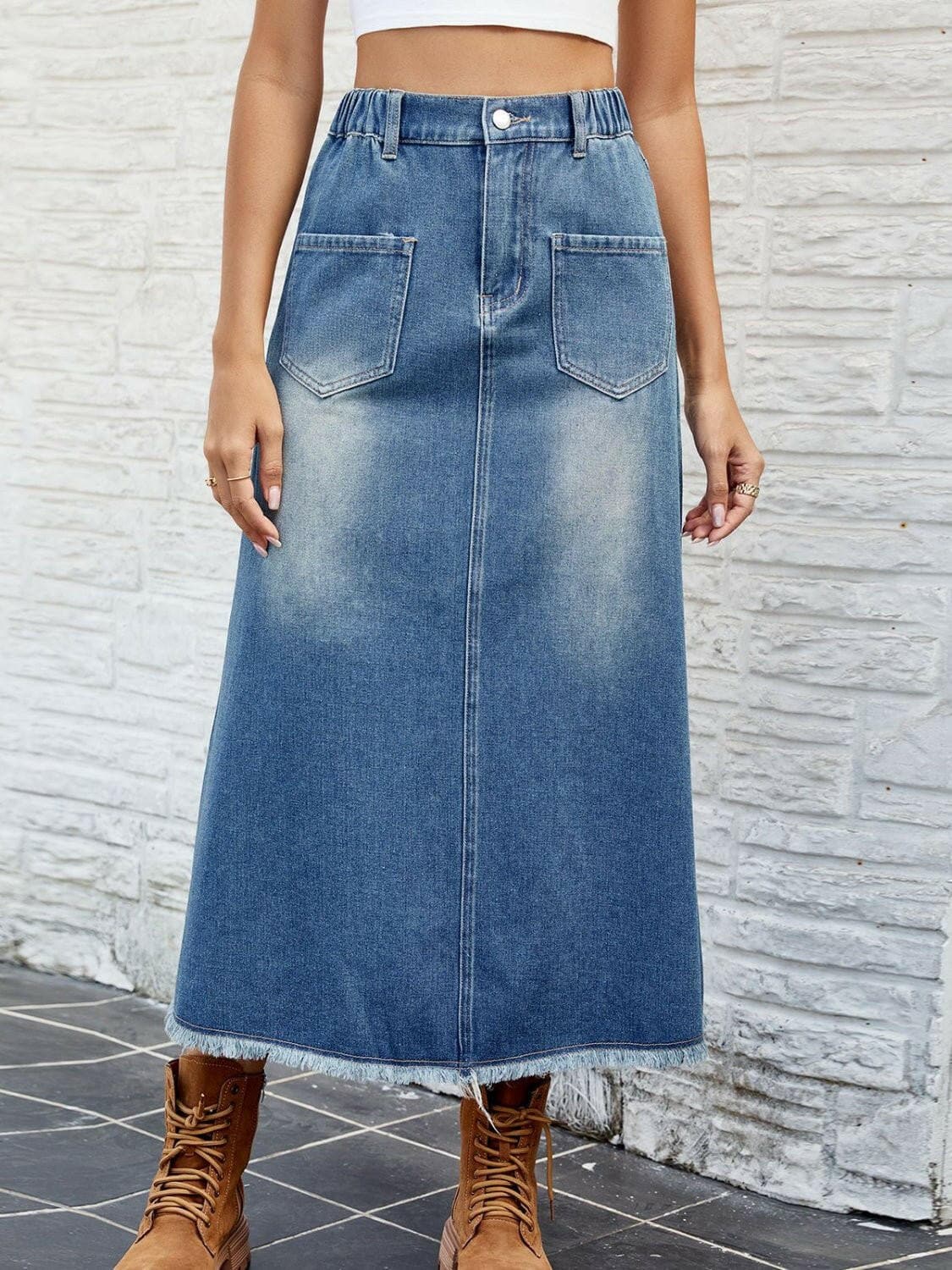 Chic denim skirt with pockets and raw hem, showcasing a buttoned design and vintage flair.