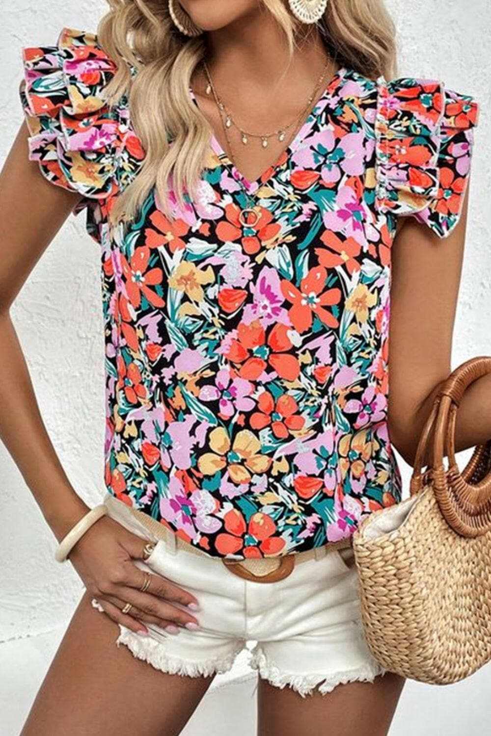 Chic ruffled V-neck cap sleeve blouse with vibrant floral prints.