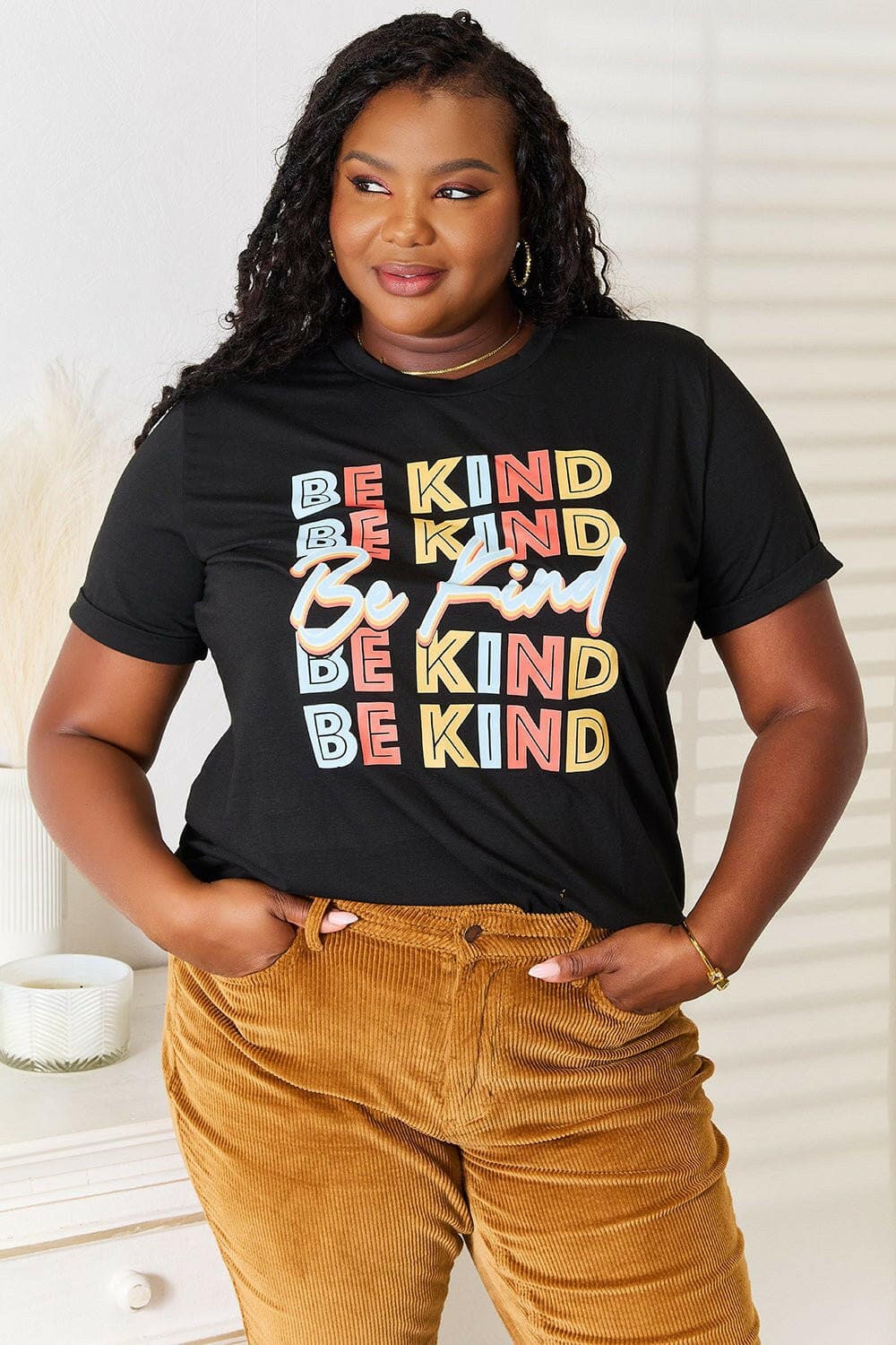 KIND Tee with colorful "Be Kind" design, radiating good vibes.