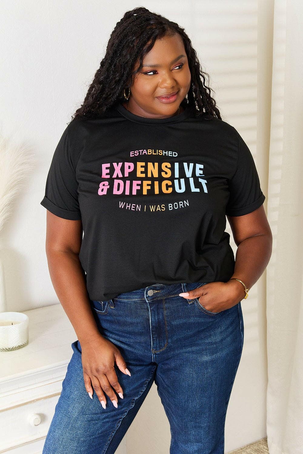 Plus-size model wearing black Simply Love Graphic Vibes Typography Tee with colorful lettering for casual elegance.