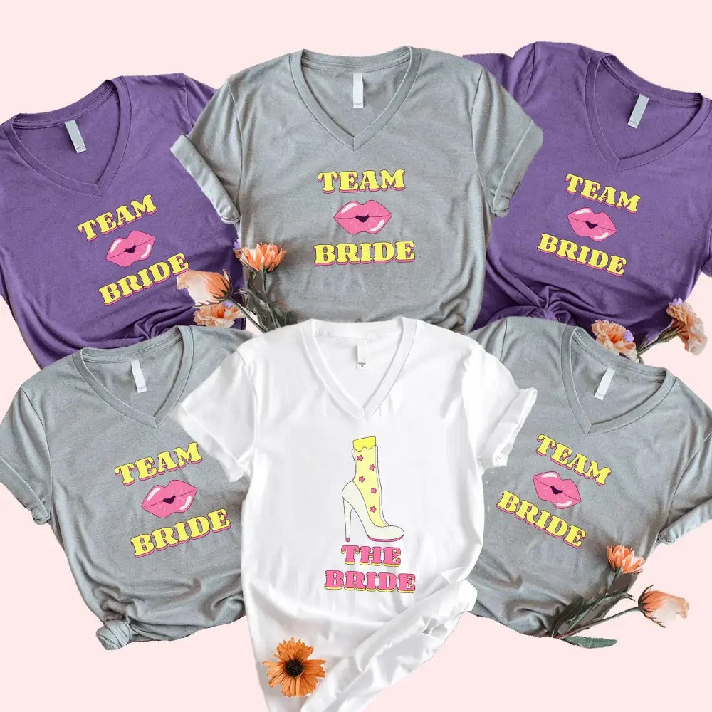Adorb.co matching bachelorette party v-neck t-shirts. White "The Bride" shirt next to a black "Team Bride" shirt with gold te