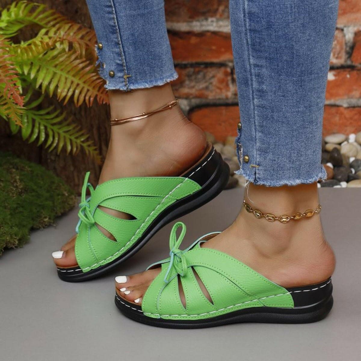 Green open toe strappy low heel sandals with jeans.