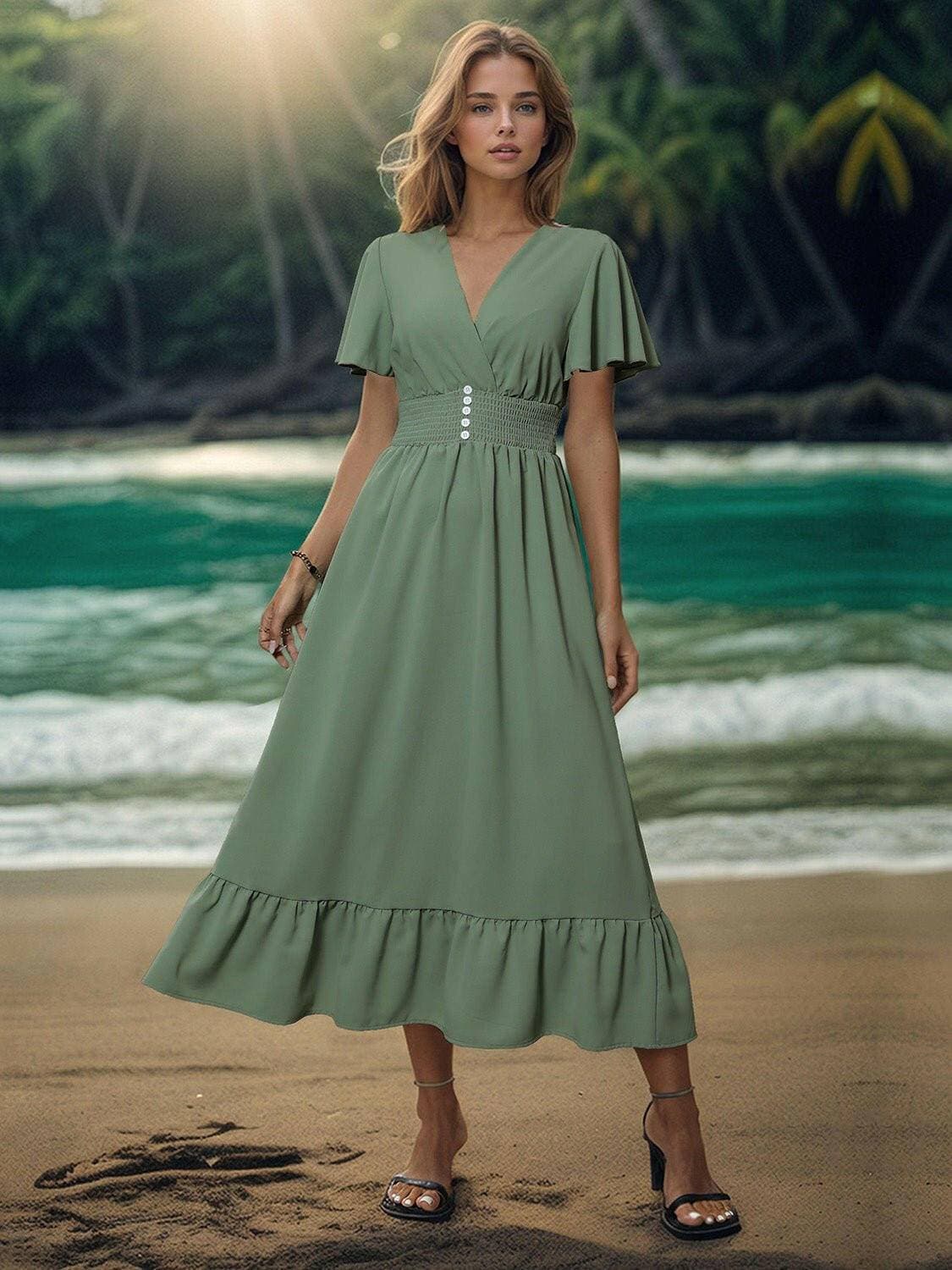 Elegant surplice flutter sleeve dress in green on a beach background.