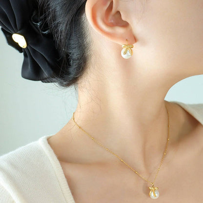 Charming golden bow drop earrings with elegant glass accents