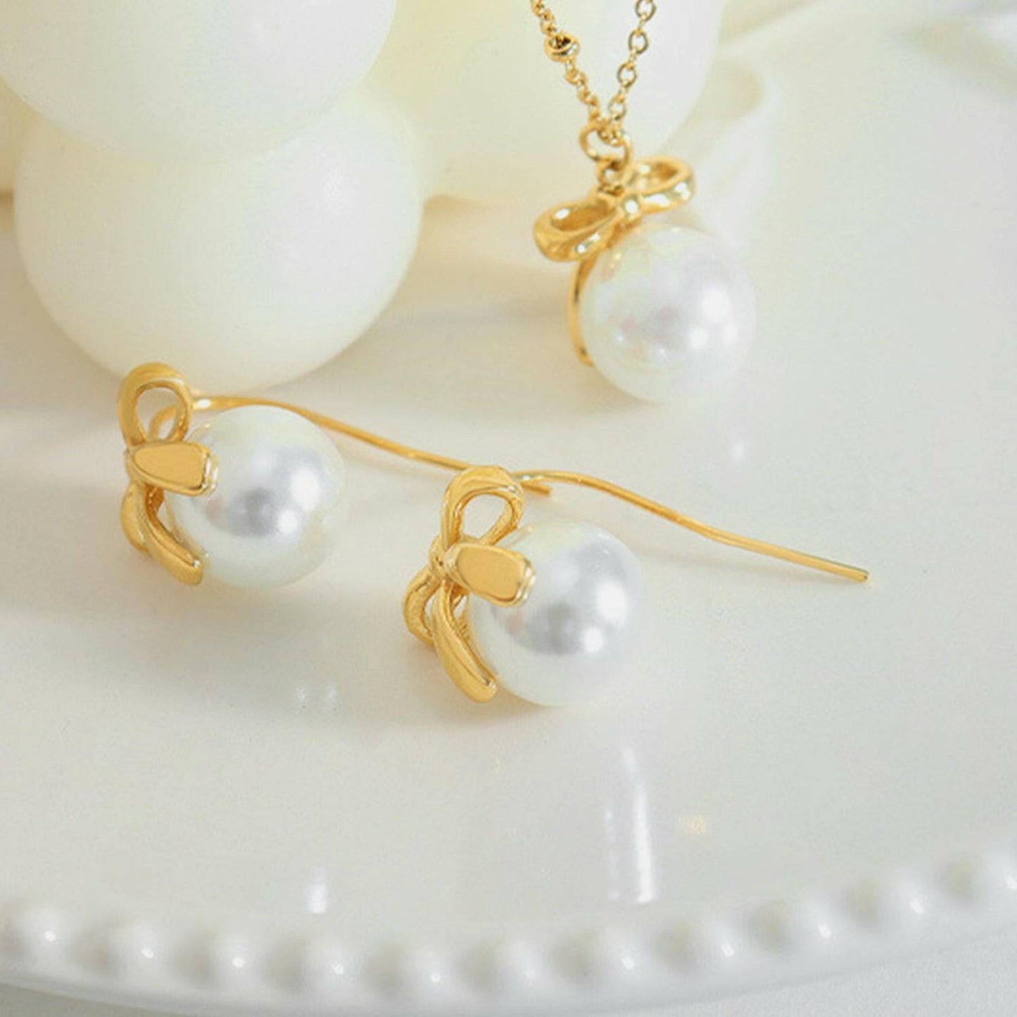 Charming golden bow drop earrings with elegant glass accents