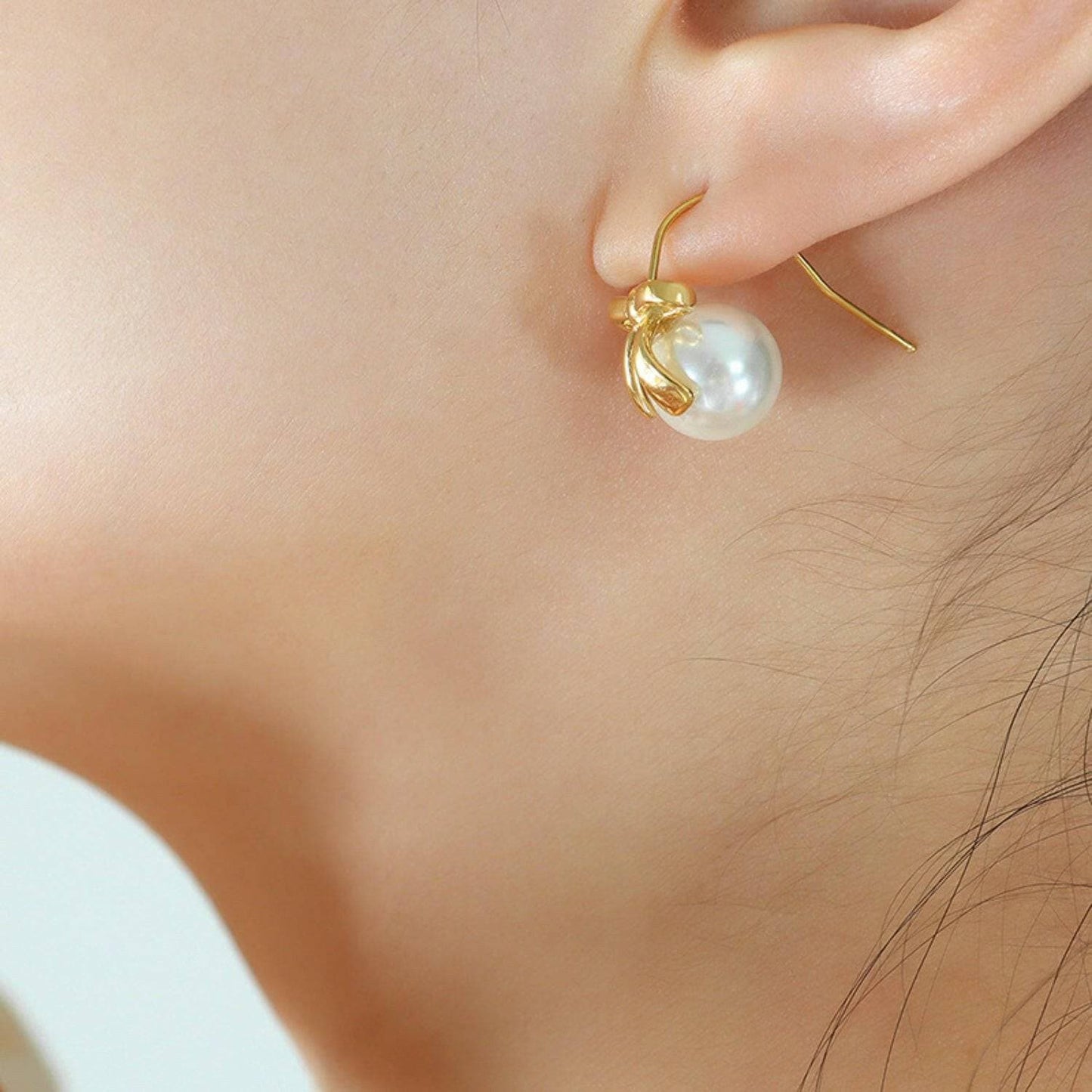 Charming golden bow drop earrings with elegant glass accents